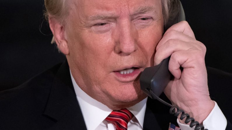 El presidente de los Estados Unidos, Donald Trump, habla por teléfono respondiendo llamadas a la línea telefónica del rastreador de Santa Claus del NORAD, en el Comedor Estatal de la Casa Blanca en Washington, DC, el 24 de diciembre de 2018. (SAUL LOEB/AFP/Getty Images)