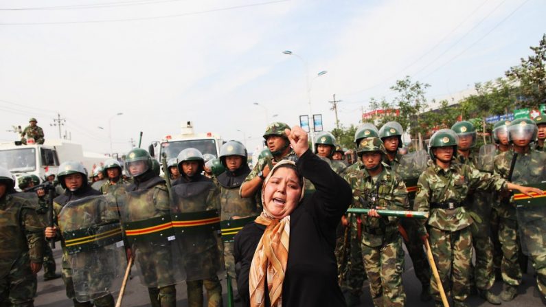 Una mujer uigur protesta frente a la policía en una calle en Urumchi, capital de Xinjiang, región autónoma uigur, China, 7 de julio de 2009. (Guang Niu/Getty Images)