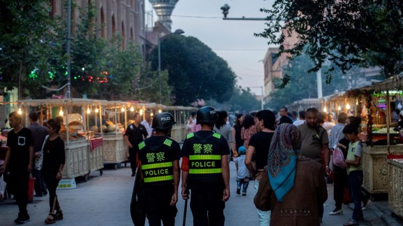 Esta foto, tomada el 25 de junio de 2017, muestra a la policía patrullando en un mercado nocturno de alimentos, en la Región Autónoma Uigur de Xinjiang, China. (JOHANNES EISELE/AFP/Getty Images)