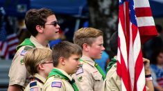 Niños luchan por doblar con respeto la bandera nacional un día de viento, ¡son muy patriotas!