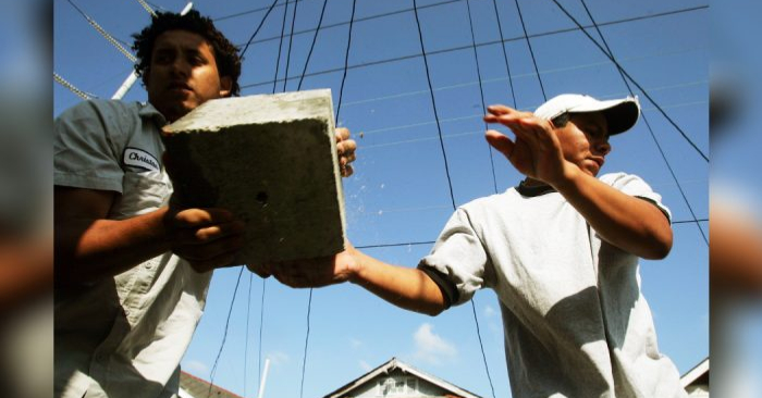 Los trabajadores migrantes José (D) de México, y Christian de Honduras, realizan trabajos de 'nivelación' en una casa dañada por el huracán Katrina, el 27 de abril de 2006, en Nueva Orleáns. (Mario Tama/Getty Images)