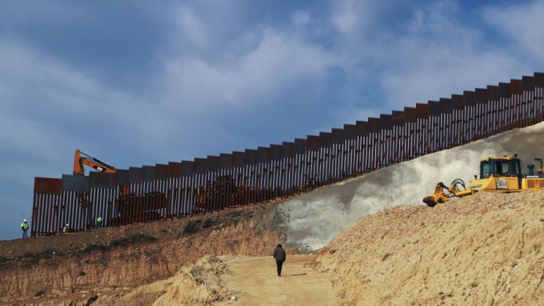 TIJUANA, MÉXICO - 11 DE ENERO: Un equipo de construcción trabaja (izq.) mientras se instalan nuevas secciones del muro fronterizo México-Estados Unidos reemplazando cercos más pequeños el 11 de enero de 2019 como se ve desde Tijuana, México. (Foto de Mario Tama/Getty Images)