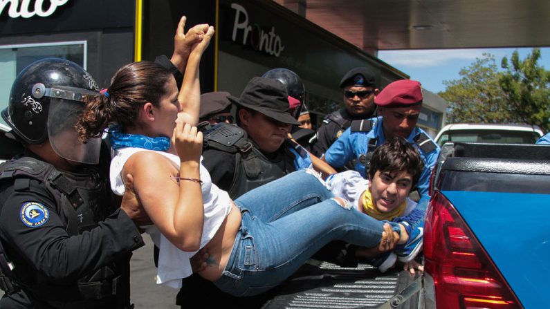 Policías antidisturbios nicaragüenses arrestan a manifestantes ante una protesta organizada por grupos opositores para exigir al gobierno la liberación de los detenidos por participar en protestas antigubernamentales, en las inmediaciones de la rotonda de Centroamerica en Managua el 16 de marzo de 2019. (MAYNOR VALENZUELA/AFP/Getty Images)
