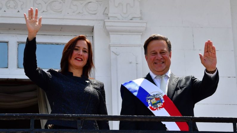 El presidente de Panamá, Juan Carlos Varela (R), y la nueva embajadora de Venezuela en Panamá, Fabiola Zavarce, saludan a los periodistas en el palacio presidencial de Las Garzas, en la ciudad de Panamá, el 18 de marzo de 2019. (LUIS ACOSTA/AFP/Getty Images)