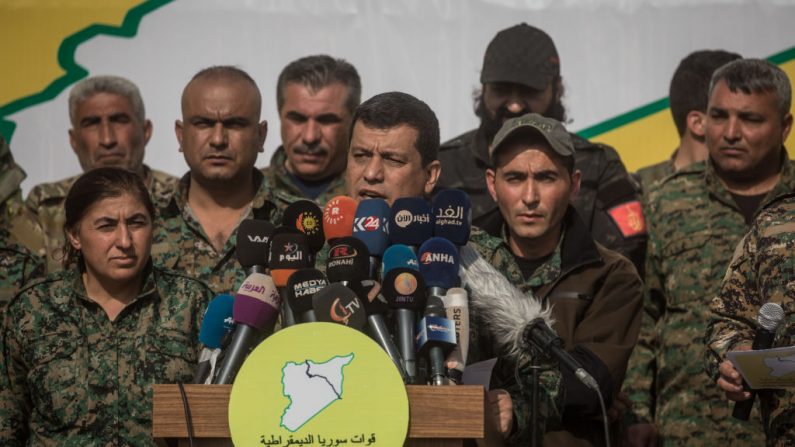 El comandante en jefe de la Fuerza Democrática Siria, Mazloum Kobani (C), habla durante una ceremonia de victoria de las Fuerzas de Defensa de Israel que anunció la derrota de ISIS en Baghouz, celebrada en el yacimiento petrolífero Omer el 23 de marzo de 2019 en Deir Al Zor, Siria. (Chris McGrath/Getty Images)