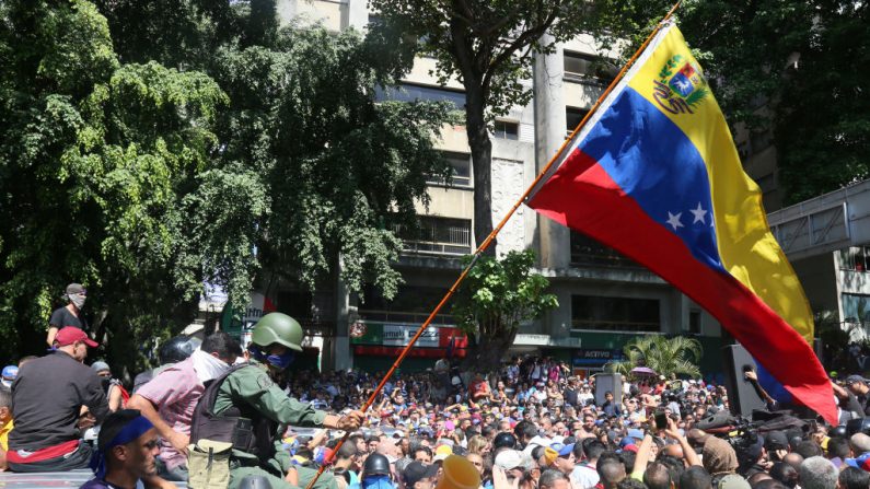 Un oficial militar desertor, que se unió a los partidarios de Juan Guaidó, ondea una bandera venezolana en la Plaza Altamira el 30 de abril de 2019 en Caracas, Venezuela. (Edilzon Gamez/Getty Images)