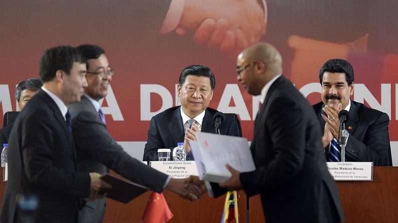 Nicolás Maduro (dcha.) y el mandatario chino Xi Jinping (3º por la dcha.) durante una ceremonia de firma de acuerdos en Caracas el 21 de julio de 2014. (LEO RAMIREZ/AFP/Getty Images)