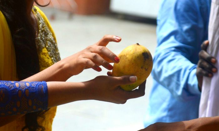 Imagen ilustrativa de una mujer tomando un mango en un mercado. (Diptendu Dutta/AFP/Getty Images)