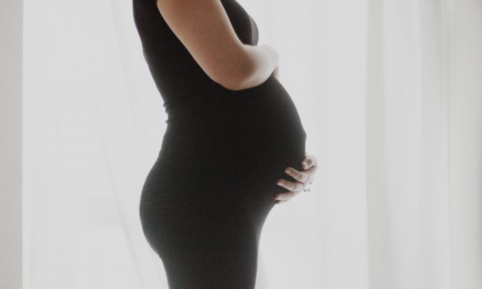 Foto de archivo de una mujer embarazada con un vestido negro.  (Michalina/Unsplash)