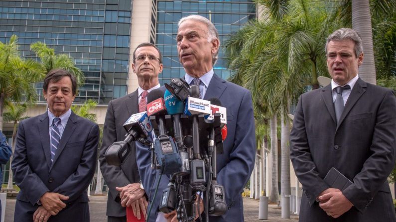 El abogado Roberto Martínez (delante), habla junto a su colega Rodney S. Margol (i atrás), y los demandantes Javier García Bengoechea (c atrás), que dice ser el legítimo propietario del puerto de Santiago de Cuba, y Mickael Behn (d), cuya familia originaria de Kentucky poseía la compañía Havana Docks Corporation en el puerto habanero, durante una conferencia de prensa este 2 de mayo, en el exterior de un tribunal federal en Miami, Florida (EE.UU.). EFE