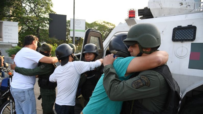 Venezolanos abrazan a miembros de las fuerzas de seguridad en Caracas luego que grupos de militares abandonaron al régimen y pasaron a apoyar al presidente encargado de Venezuela, Juan Guaidó, el 30 de abril de 2019. Foto de YURI CORTEZ/AFP/Getty Images.