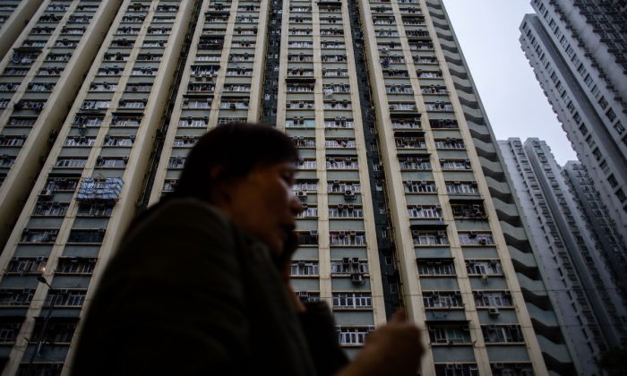 Imagen ilustrativa de un edificio residencial de gran altura en China. Una mujer al teléfono frente a un edificio residencial de gran altura. (Anthony Wallace/AFP/Getty Images)