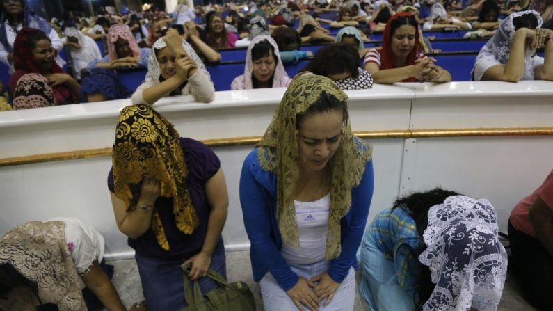 Fieles de la evangélica Iglesia la Luz del Mundo se congregan durante la madrugada del 5 de junio, en su sede de Guadalajara (oeste de México), para rezar por la liberación de su líder, Naasón Joaquín García, detenido en Estados Unidos por trata de personas, pornografía infantil y abuso sexual de menores. EFE/Francisco Guasco