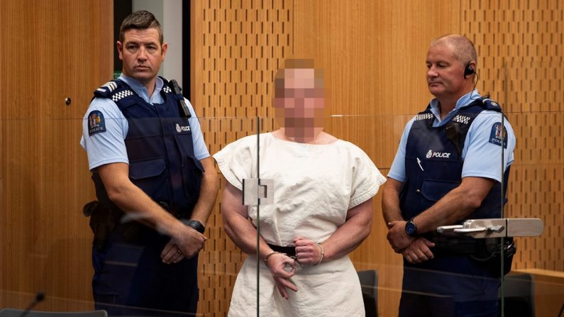 Brenton Tarrant (c), el autor del ataque contra dos mezquitas en Nueva Zelanda, mientras hace un gesto a la cámara durante su comparecencia ante el Tribunal de Distrito de Christchurch (Nueva Zelanda). EFE/Archivo