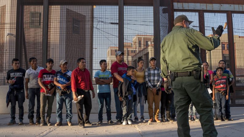 Una fila de migrantes, en su mayoría de América Central, abordan una camioneta que los llevará a un centro de procesamiento, el 16 de mayo de 2019, en El Paso, Texas. (Créditos: Paul Ratje/AFP/Getty Images)