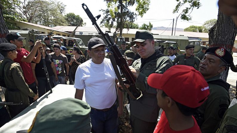 El entonces ministro de Defensa de Venezuela, Vladimir Padrino López, hoy parte del régimen de dictadura de Nicolás Maduro, maneja un rifle Kalashnikov durante un ejercicio con miembros de la Milicia Bolivariana en Valencia, 120 km al oeste de Caracas el 21 de marzo de 2015. (JUAN BARRETO/AFP/Getty Images)