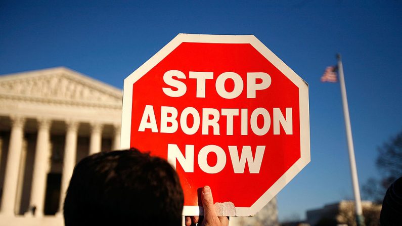 Un activista provida sostiene un letrero frente a la Corte Suprema de los Estados Unidos que dicen "Detengan el aborto ahora", mientras participa en el evento anual "Marcha por la Vida" el 22 de enero de 2009 en Washington, DC. (Alex Wong/Getty Images)