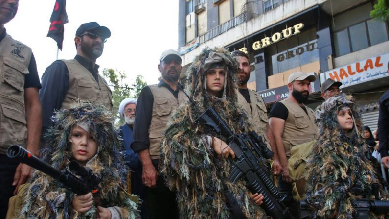 Niños vestidos con ropa militar llevan armas durante una congregación de la organización terrorista Hezbolá, el 4 de octubre de 2017. (MAHMOUD ZAYYAT/AFP/Getty Images)