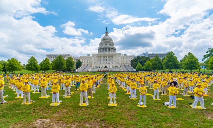 Los practicantes de Falun Dafa realizan sus ejercicios en un acto conmemorativo del 20º aniversario de la persecución a Falun Dafa en China, en el jardín oeste del Capitolio el 18 de julio de 2019. (Mark Zhou/La Gran Época)
