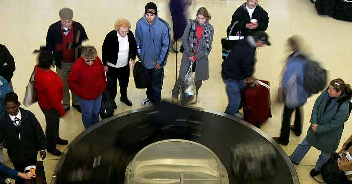 Foto ilustrativa de gente que espera cerca de una cinta transportadora de equipaje en un aeropuerto. Foto de Mark Wilson/Getty Images.