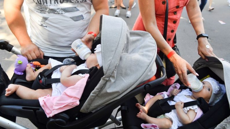 Los padres alimentan a sus bebés gemelos mientras asisten al Festival de Gemelos para niños, en Kiev, el 11 de agosto de 2018.(SERGEI SUPINSKY / AFP / Getty Images)