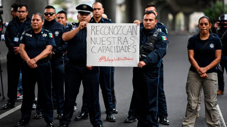 Miembros de la Policía Federal bloquean el Anillo Periférico frente a la sede de la Policía Federal en la Ciudad de México el 3 de julio de 2019 para protestar contra la anexión de la fuerza a la recién formada Guardia Nacional. (RONALDO SCHEMIDT/AFP/Getty Images)