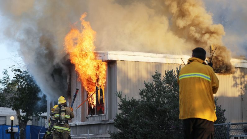  Los bomberos trabajan para apagar un incendio en la casa. (Crédito: ROBYN BECK/AFP/Getty Images)