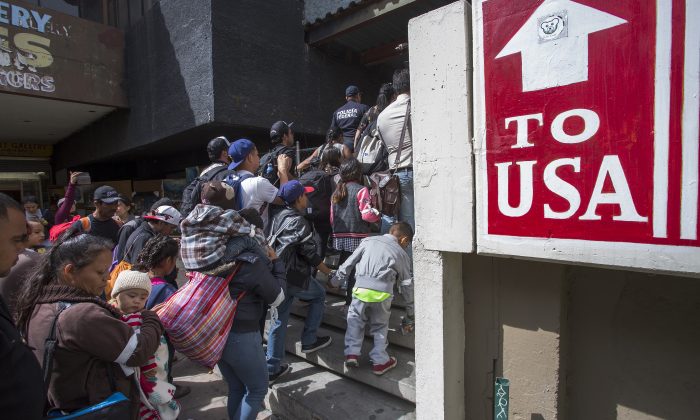 Miembros de una caravana de centroamericanos que pasaron semanas viajando a través de México, caminan desde México hasta el lado estadounidense de la frontera para pedir asilo a las autoridades en Tijuana, Baja California Norte, México, el 29 de abril de 2018. (David McNew/Getty Images)