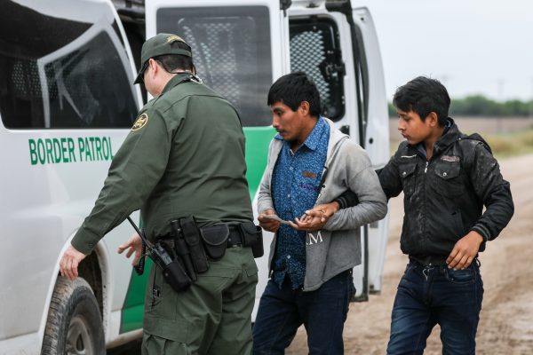 Un agente de la Patrulla Fronteriza detiene a extranjeros ilegales que acaban de cruzar el Río Grande desde México hacia Penitas, Texas, el 21 de marzo de 2019. (Charlotte Cuthbertson/La Gran Época)