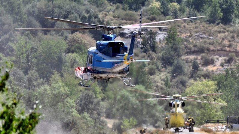Dos de los helicópteros que participaron en las labores de extinción del incendio forestal declarado en el Real Sitio de San Ildefonso-La Granja, España. EFE/Pablo Martín García
