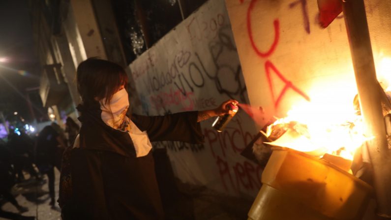 Foto de archivo de feministas rompiendo vidrios y quemando papeles al interior de un edificio durante una marcha en Ciudad de México, México. (Sashenka Gutiérrez/EFE)