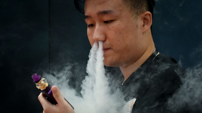 Un promotor de una empresa de e-cigarrillos fuma un cigarrillo electrónico en la Exposición Internacional de Electrónica de Consumo de Beijing el 28 de junio de 2019. (WANG ZHAO/AFP/Getty Images)
