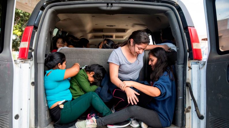 Migrantes centroamericanos, parte de un grupo de 87 personas deportadas de Estados Unidos, esperan en una camioneta en el cruce fronterizo de El Chaparral antes de ser transportados a un refugio en Tijuana, México, el 22 de julio de 2019. (EDUARDO JARAMILLO CASTRO/AFP/Getty Images)
