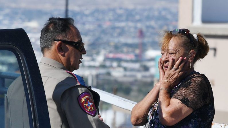 Virginia Chacon reacciona cuando le cuenta su historia de supervivencia a un oficial de policía afuera del Wal-Mart Cielo Vista, donde un tiroteo dejó 22 personas muertas en El Paso, Texas, el 4 de agosto de 2019. (MARK RALSTON/AFP/Getty Images)
