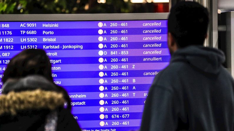 Pasajeros miran los vuelos cancelados en una pantalla informativa. EFE/Amando Babani/Archivo