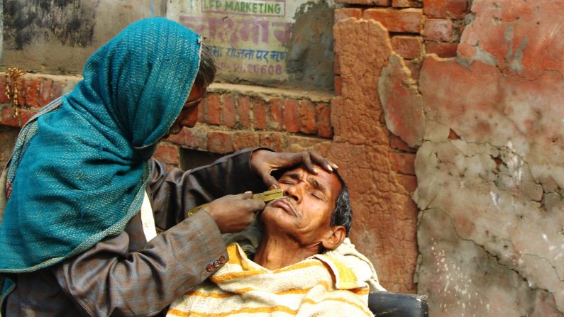 Imagem ilustrativa de um barbeiro na Índia fazendo seu trabalho (noelmcshane | Pexels)
