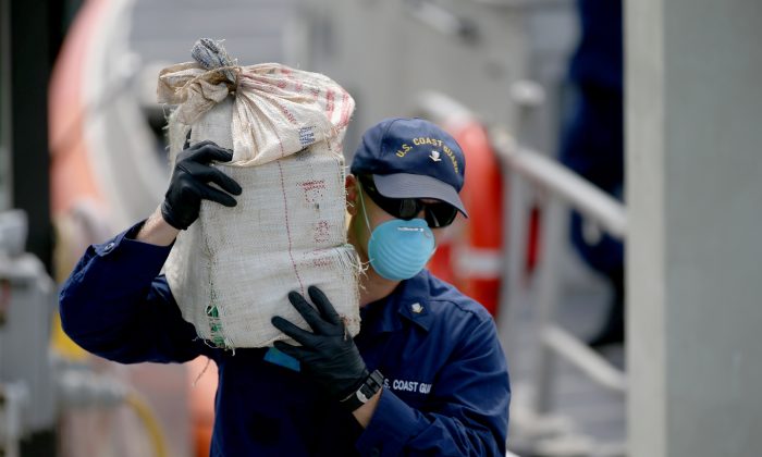 Un miembro de la Guardia Costera de Estados Unidos ayuda a descargar bolsas de cocaína incautada por un valor estimado de más de 23 millones de dólares en Miami Beach, Florida, el 18 de septiembre de 2014. (Joe Raedle/Getty Images)