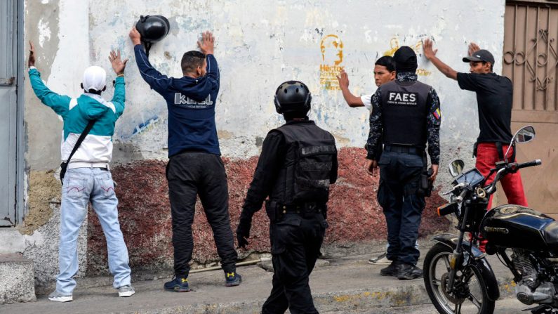 Miembros del Grupo de Fuerzas Especiales de la Policía Nacional Bolivariana (FAES) detienen a un grupo de hombres durante un operativo en el barrio de Petare, en Caracas, el 25 de enero de 2019. (Foto de LUIS ROBAYO/AFP/Getty Images)