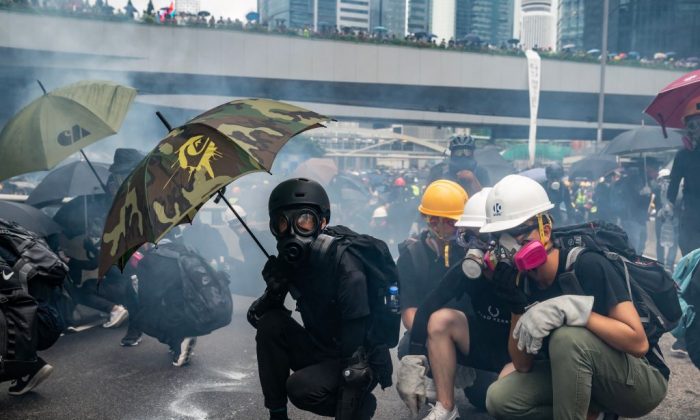 Manifestantes se enfrentan a la policía en una nube de gas lacrimógeno durante una confrontación afuera del Complejo del Gobierno Central en Hong Kong, el 31 de agosto de 2019. (Anthony Kwan/Getty Images)