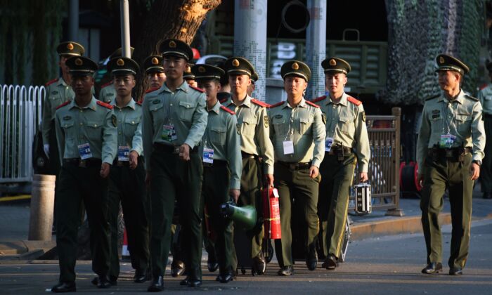 La policía paramilitar china camina en una calle junto a la plaza de Tiananmen antes de un ensayo nocturno de un desfile militar para conmemorar el 70º aniversario de la China comunista, en Beijing, el 7 de septiembre de 2019. (GREG BAKER/AFP/Getty Images)

