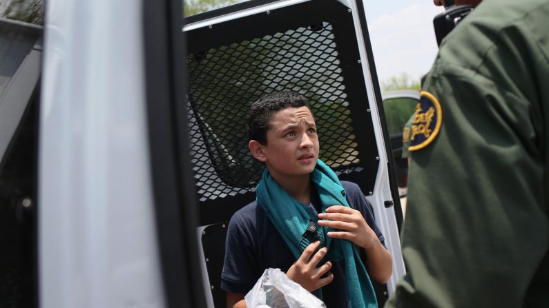 Un agente de la Patrulla Fronteriza de los EE.UU. se prepara para llevar a un menor salvadoreño no acompañado, de 13 años, a un centro de procesamiento después de cruzar el Río Grande desde México hacia los Estados Unidos el 24 de julio de 2014 en Mission, Texas. (John Moore/Getty Images)