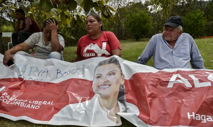 Parentes e amigos da candidata a prefeita assassinada Karina Garcia choram diante de um cartaz que anunciava sua campanha em Suarez, Cauca, Colômbia, em setembro. 2 de 2019 (Luis Robayo / AFP / Getty Images)