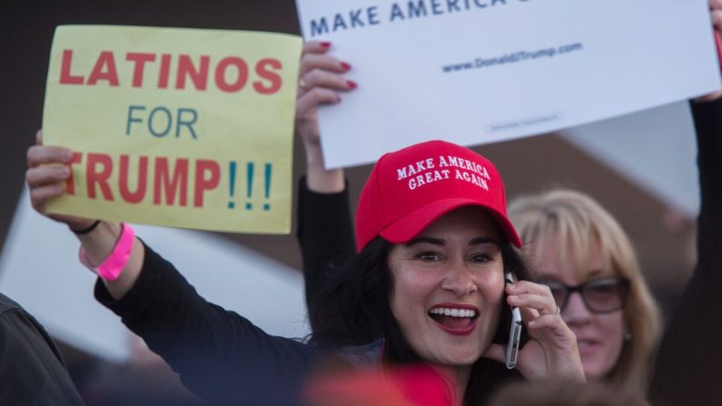 Una mujer sostiene un cartel que expresa el apoyo latino al candidato presidencial republicano Donald Trump en su mitin de campaña en el Centro de Eventos y Feria del Condado de Orange, el 28 de abril de 2016, en Costa Mesa, California. (DAVID MCNEW/AFP/Getty Images)