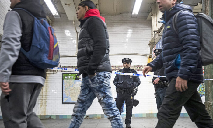Pasajeros bajan de un tren cuando un oficial de policía se para en una pasarela acordonada de la estación de metro en Nueva York, el 11 de diciembre de 2017. (Drew Angererer/Getty Images)