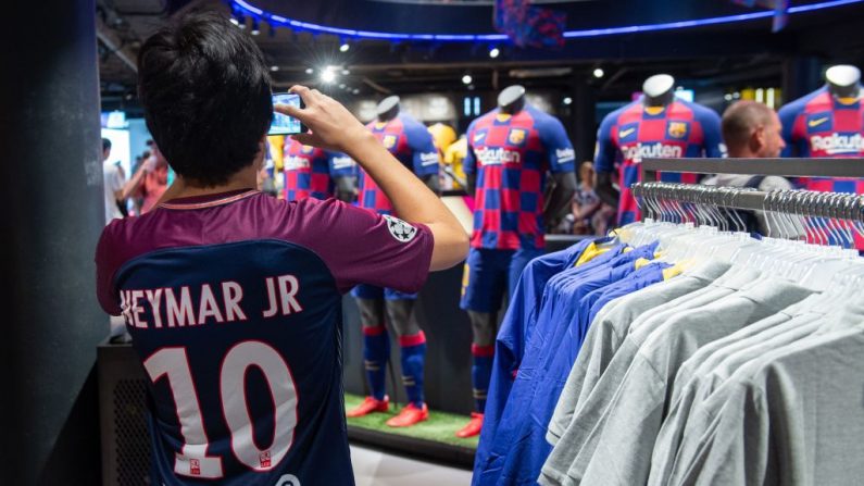Um garoto vestindo uma camisa do PSG com o nome de atacante brasileiro Neymar Jr tira fotos na loja oficial do Barcelona FC em Barcelona em 2 de agosto de 2019 (Foto por JOSEP LAGO / AFP / Getty Images)