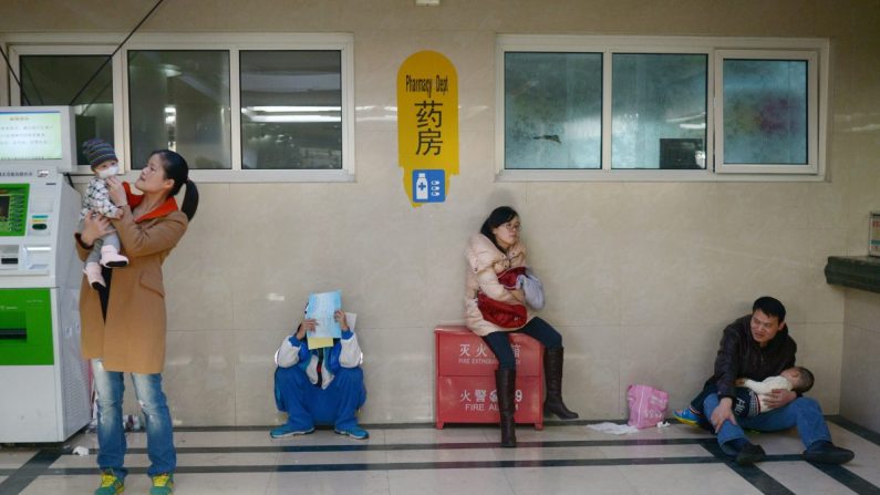 Pais com seus filhos em um hospital na China (Wang Zhao / AFP / Getty Images)