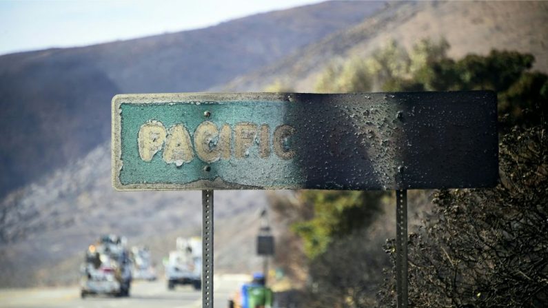 Um sinal da Costa do Pacífico danificado pelo fogo permanece parado ao longo da Rodovia da Costa do Pacífico, em meio às colinas escurecidas e carbonizadas do incêndio de Woolsey em Malibu, Califórnia, em 15 de novembro de 2018 (Foto por FREDERIC J. BROWN / AFP / Getty Images)
