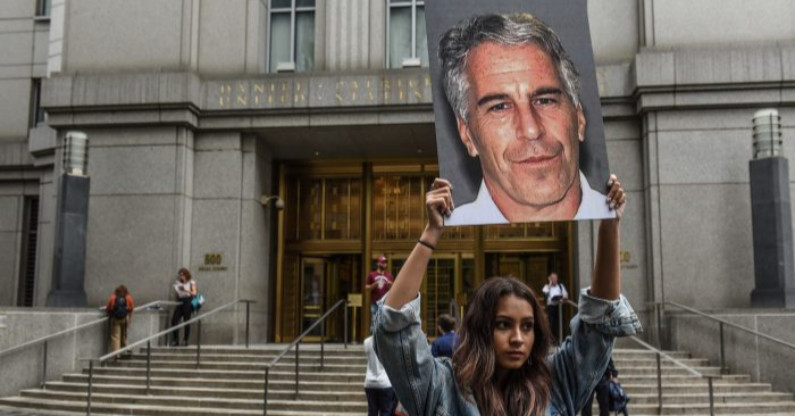 Grupo ativista chamado "Hot Mess" segura cartazes com a imagem de Jeffrey Epstein em frente ao tribunal federal da cidade de Nova Iorque em 8 de julho de 2019 (Stephanie Keith / Getty Images)