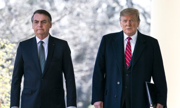 O presidente dos EUA, Donald Trump (D), e o presidente do Brasil, Jair Bolsonaro (E), andam pela Colunata antes de uma conferência de imprensa no Jardim de Rosas da Casa Branca, em Washington, DC, em 19 de março de 2019.