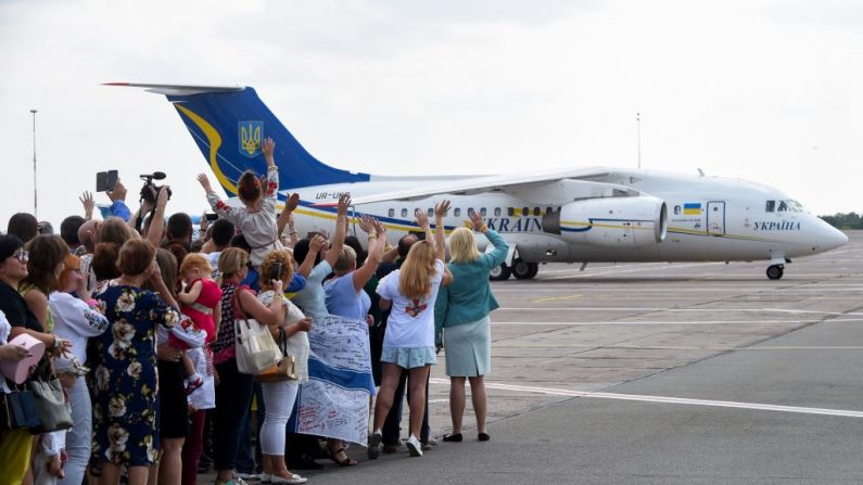 Amigos e parentes acenam para um avião que transportava ex-prisioneiros, em 7 de setembro de 2019, no aeroporto internacional Boryspil em Kiev, após uma tão esperada troca de prisioneiros entre Moscou e Kiev, um dia depois que o presidente russo disse pela primeira vez que o intercâmbio de prisioneiros "em larga escala" com a Ucrânia estava sendo finalizado. O presidente da Ucrânia, Volodymyr Zelensky, em 7 de setembro de 2019 saudou uma troca de prisioneiros com a Rússia como o primeiro passo para acabar com a guerra no leste da Ucrânia e retornar ao território anexado por Moscou (Foto por SERGEI SUPINSKY / AFP / Getty Images)